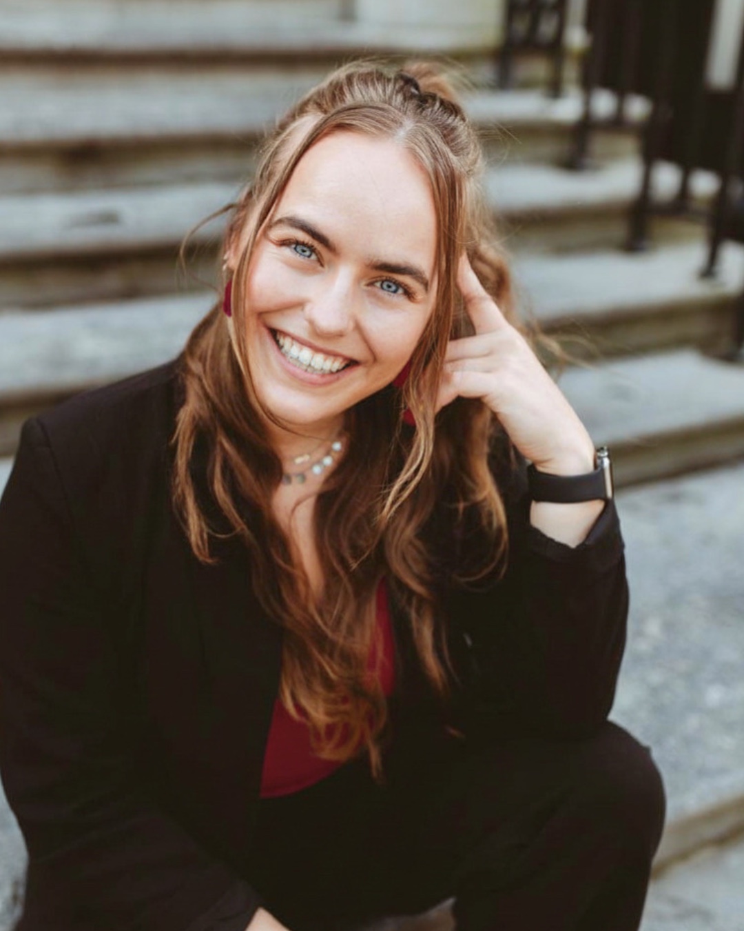 Robin Couprie, lachend, zittend op een stenen trap